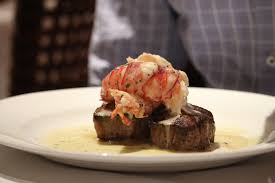 The Capital Grille signature dishes Kona Crusted Bone-In Strip with Shallot Butter, Seared Tenderloin with Butter Poached Lobster Tail, and Lobster Mac-and-Cheese 